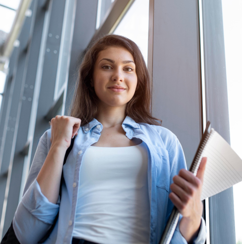 Chica posando con un cuaderno.
